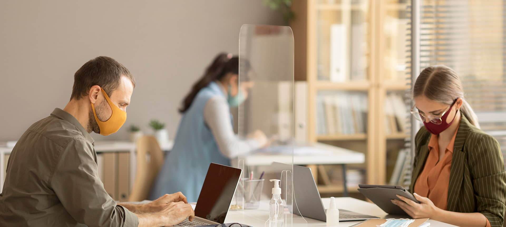 Two employees wearing masks why working in the office 