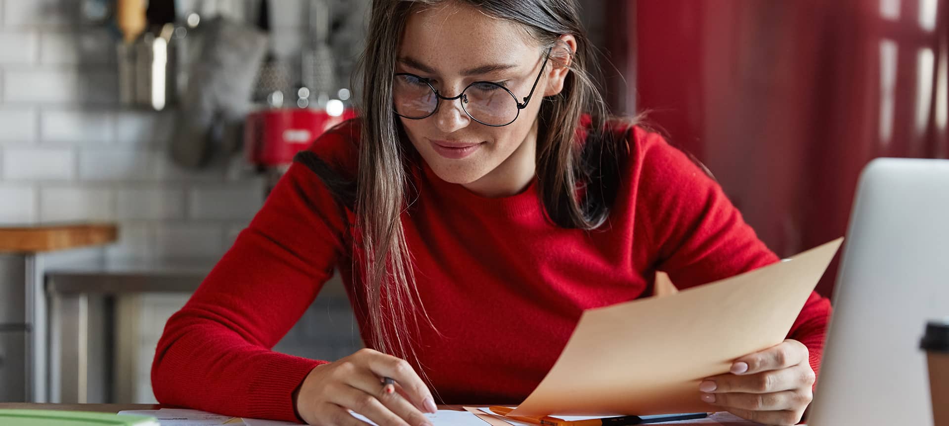 The Best Guide to Rock Your Next Video Assessment Interview | Elevatus A female candidate holding a paper and working on her laptop.