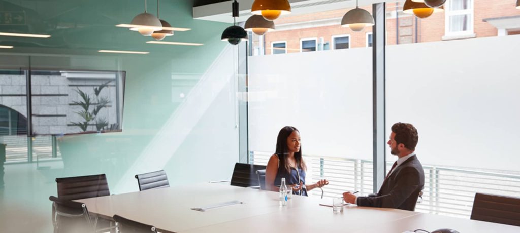 Find Top Talent With These 8 Great Interview Questions For Business Development | Elevatus A female candidate discussing her preferred methods with a male recruiter.