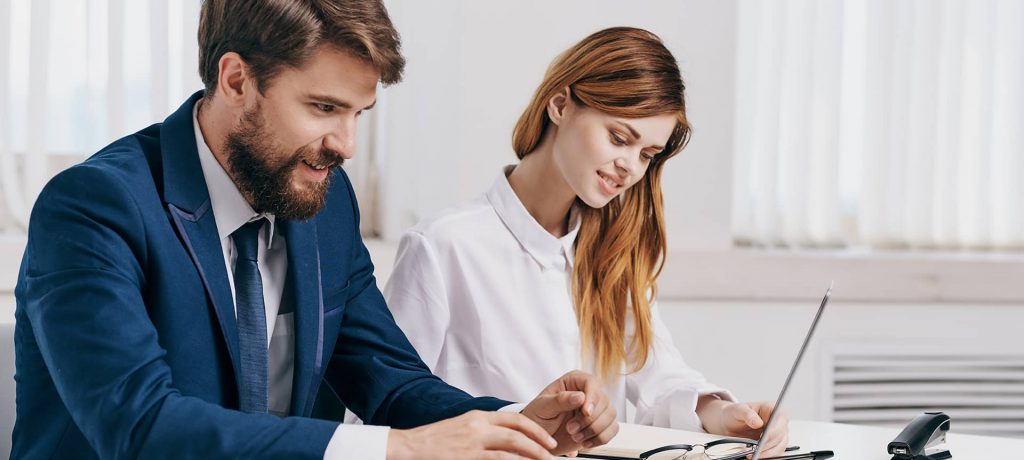 A female and male recruiter working on their laptops to boost engagement with candidates. 