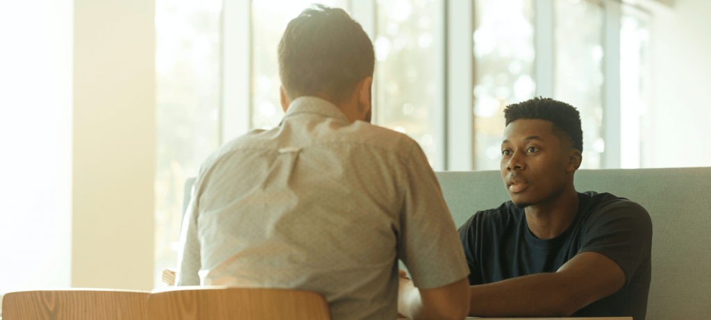 Top 10 Ice Breaker Interview Questions That Build Connection and Reveal True Talent for Successful Hiring | Elevatus Man discussing the power of ice breaker interview questions with a co-worker