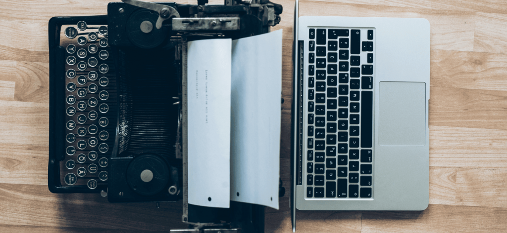 An image of an old typewriter and a laptop