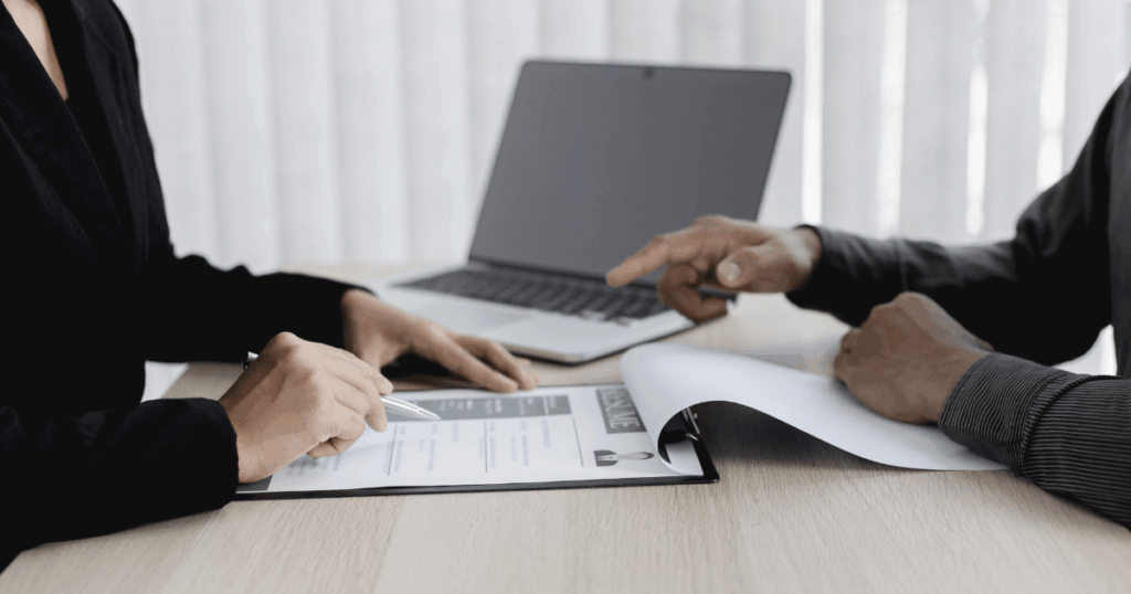 An image of two people in business attire discussing roles in a job interview.

